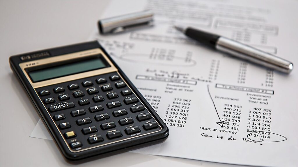 Calcolatrice finanziaria e penna su un prospetto di cifre, per calcolare un saldo e stralcio
