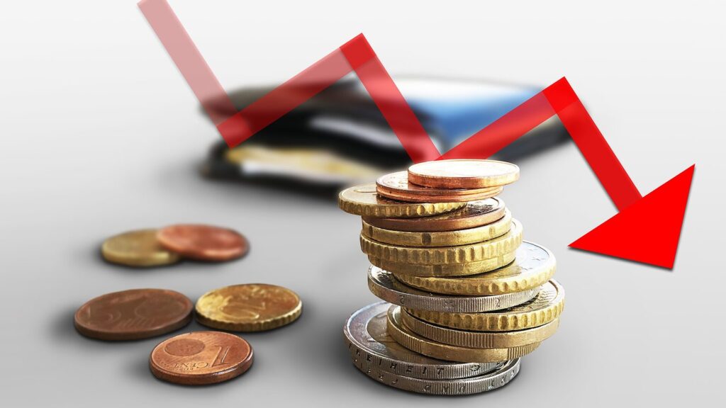Pila di monete in euro e portafoglio con una freccia rossa in discesa, simbolo dei debiti